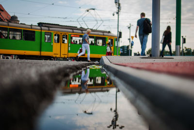 People walking by tram in city