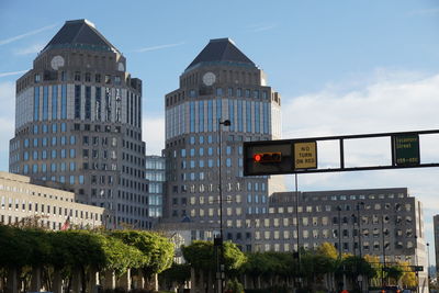 Low angle view of road sign against sky in city