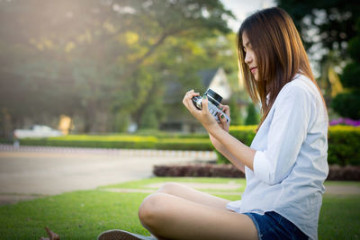 Young woman photographing with mobile phone