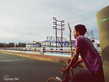 Side view of man riding bicycle on road