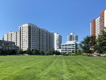 Buildings in city against clear blue sky