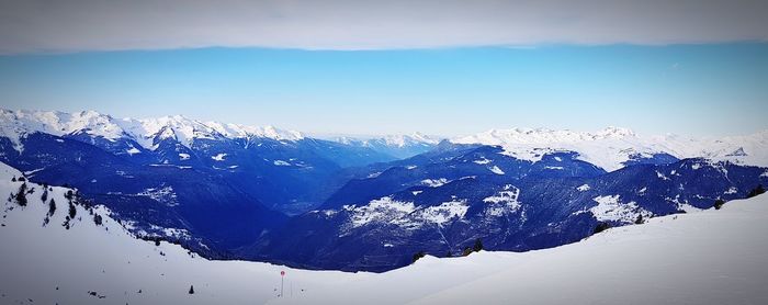 Snow covered mountain against blue sky