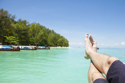 Low section of man in sea against sky