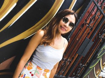 Portrait of young woman standing against wall