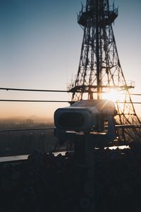 Close-up of electricity pylon against sunset sky