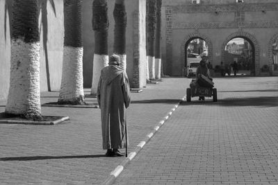 Rear view of man walking on street in city