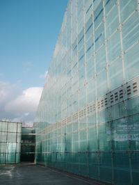 Low angle view of glass building against sky