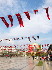 Low angle view of flags hanging against sky