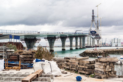 Incomplete la pepa bridge over sea against cloudy sky