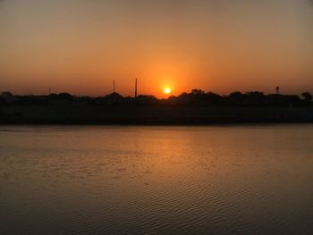Scenic view of river against orange sky