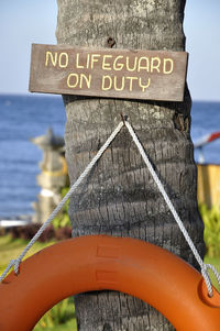 Close-up of wooden post by sea against sky