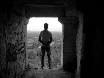 Rear view of man standing in abandoned building