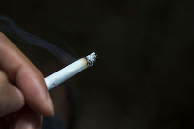 Close-up of hand holding cigarette