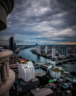 High angle view of buildings by river against sky