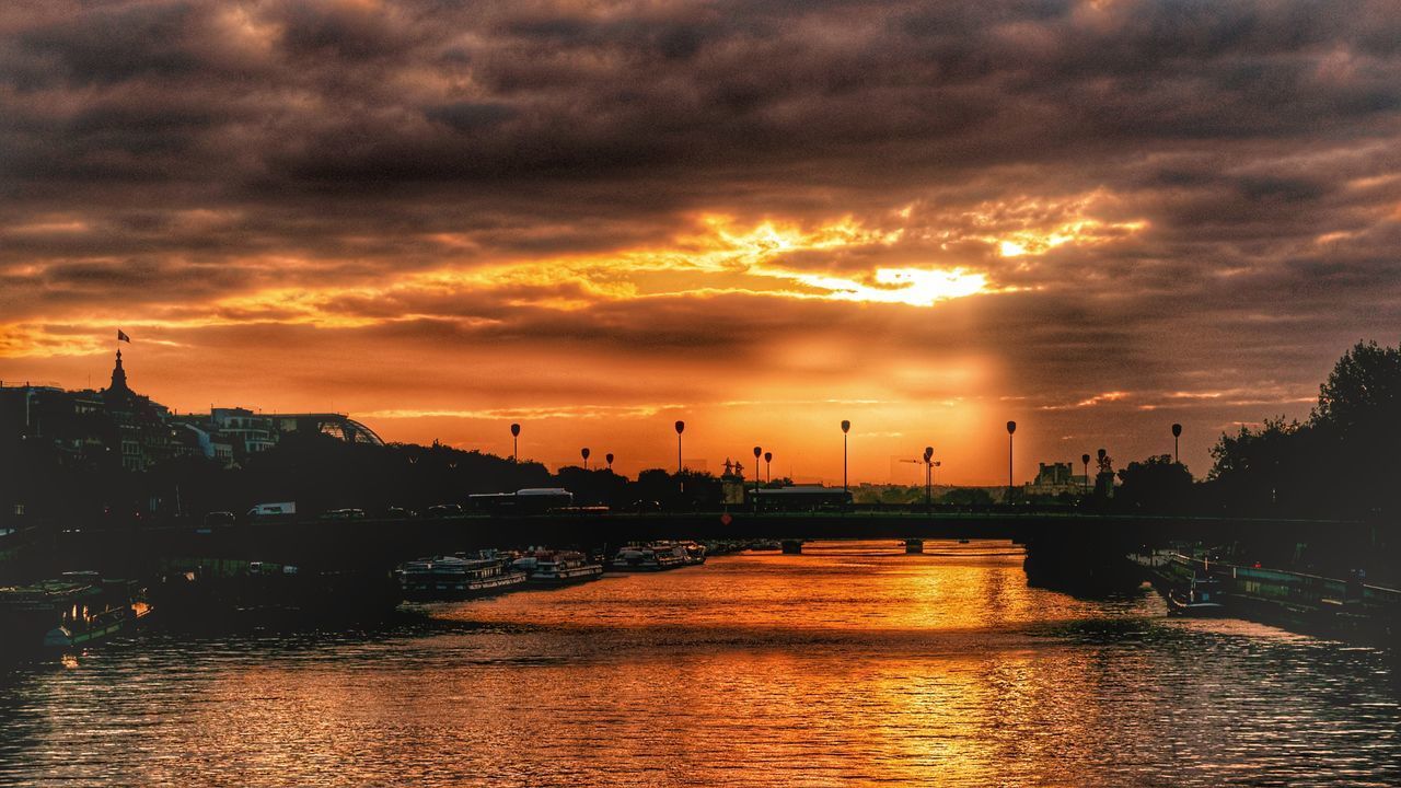 VIEW OF RIVER AGAINST DRAMATIC SKY DURING SUNSET