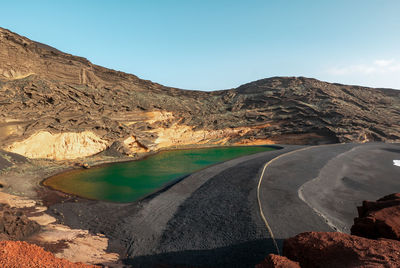 Scenic view of road by mountain against sky