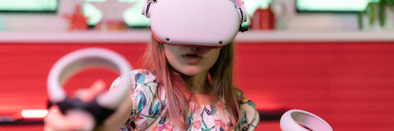 Vr game virtual reality. kid girl gamer playing on futuristic simulation video game in 3d glasses