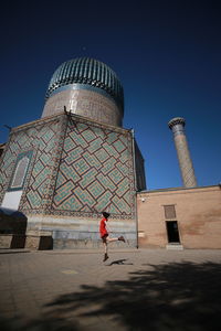 Man standing outside building against blue sky