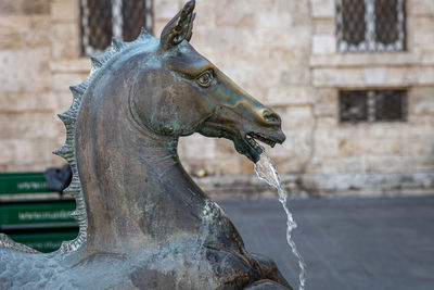 Statue of fountain against building