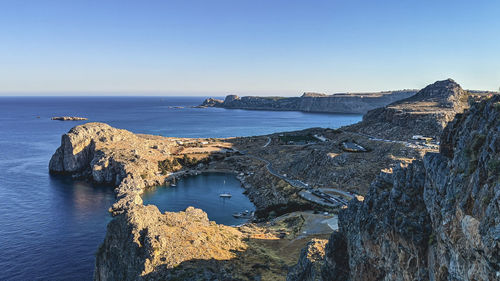 Greece, lindos acropolis - june 17, 2021. view of the coast of the island with a heart-shaped bay,