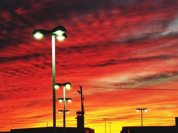 Low angle view of illuminated street light against sky at sunset