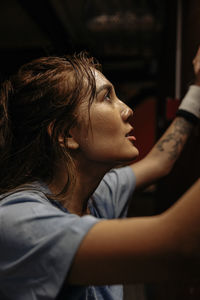 Side view of determined female athlete working out in gym