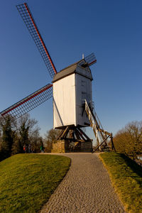 Traditional windmill on field against clear sky