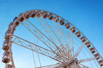 Low angle view of ferris wheel against blue sky
