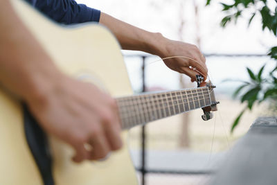 Midsection of man playing guitar