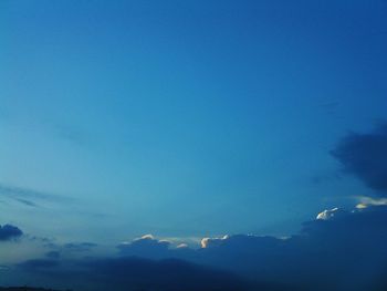 Low angle view of birds flying against blue sky