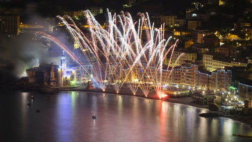 Firework display over river at night