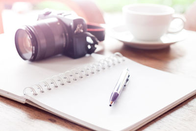 Close-up of pen and camera on book