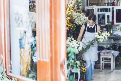 Owner arranging bunch of flowers in shop