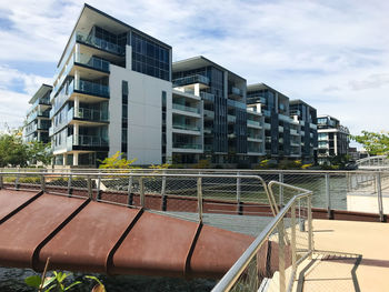 Buildings by swimming pool in city against sky