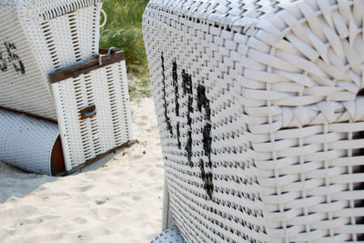 Close-up of hooded beach chairs on sand
