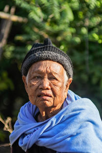 Woman looking away against trees