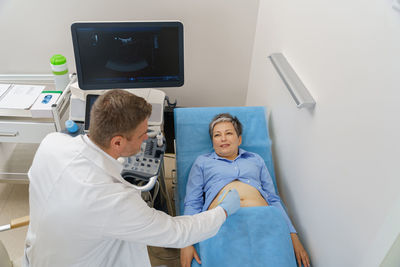 High angle view of woman using digital tablet while sitting on table