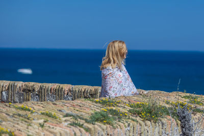 Woman standing at beach against sky