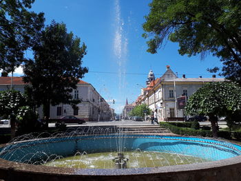 Water fountain in swimming pool against sky