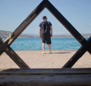 Rear view of man standing on beach