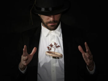 Magician performing magic over black background