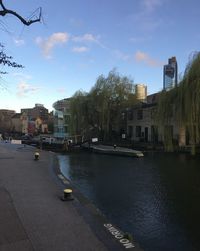 River by buildings in city against sky