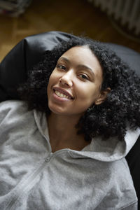 Portrait of smiling young woman lying on bean bag