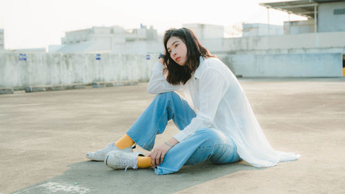 Side view of young woman sitting outdoors