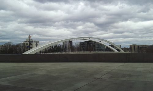 Bridge over river against cloudy sky