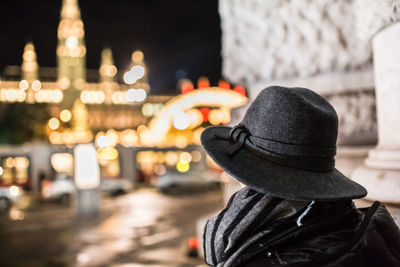 Rear view of woman in illuminated city at night