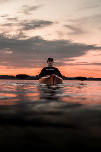 Man swimming in sea during sunset