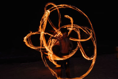 Fire dancer performing on field at night