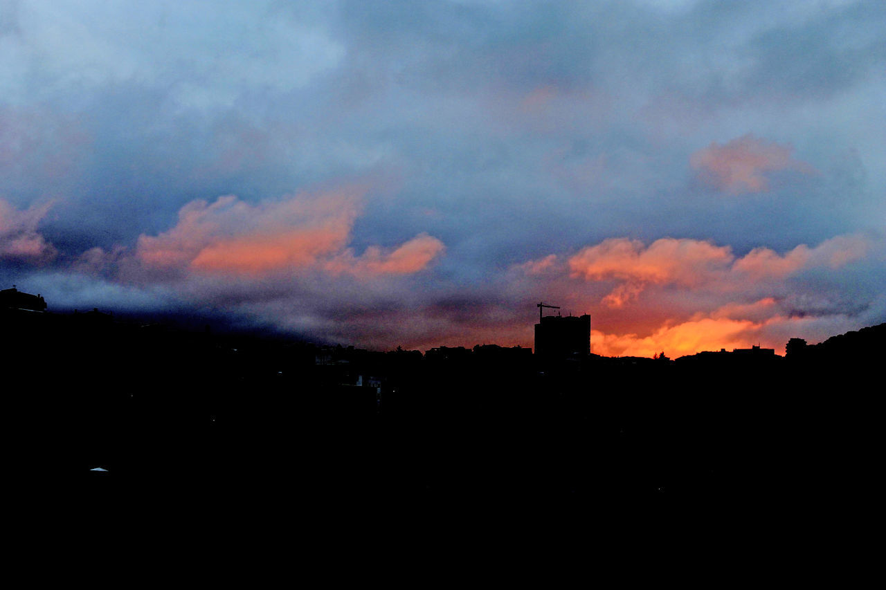 SILHOUETTE BUILDINGS AGAINST DRAMATIC SKY