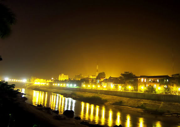 ILLUMINATED CITY AT WATERFRONT